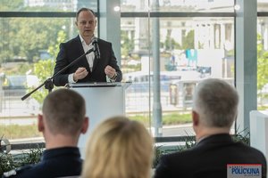 na zdjęciu mężczyzna za mównica w trakcie przemówienia