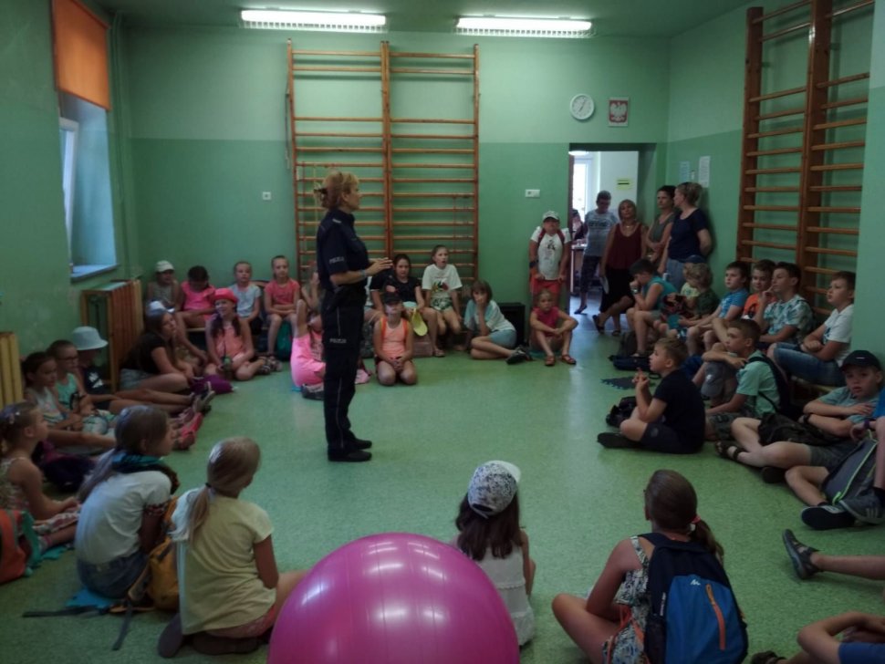 Fotografia kolorowa. Na zdjęciu widoczna policjantka prowadząca zajęcia z dziećmi. 