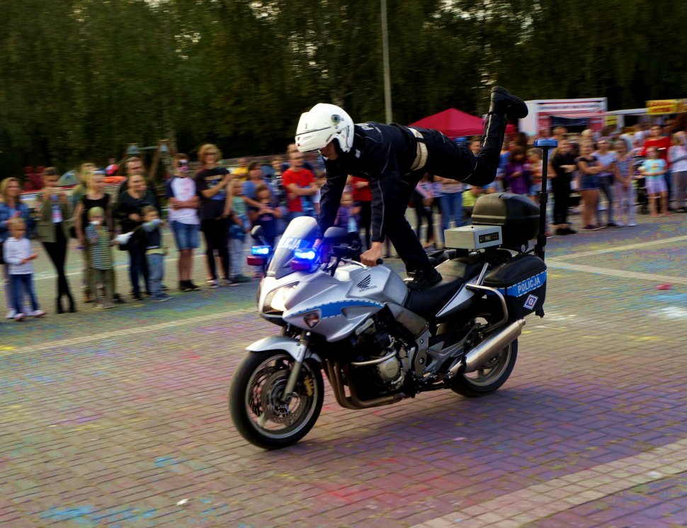 Fotografia kolorowa. Na zdjęciu policjant podzas pokazu jazdy na motocyklu