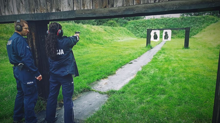 Na zdjęciu policjantka oddająca strzał