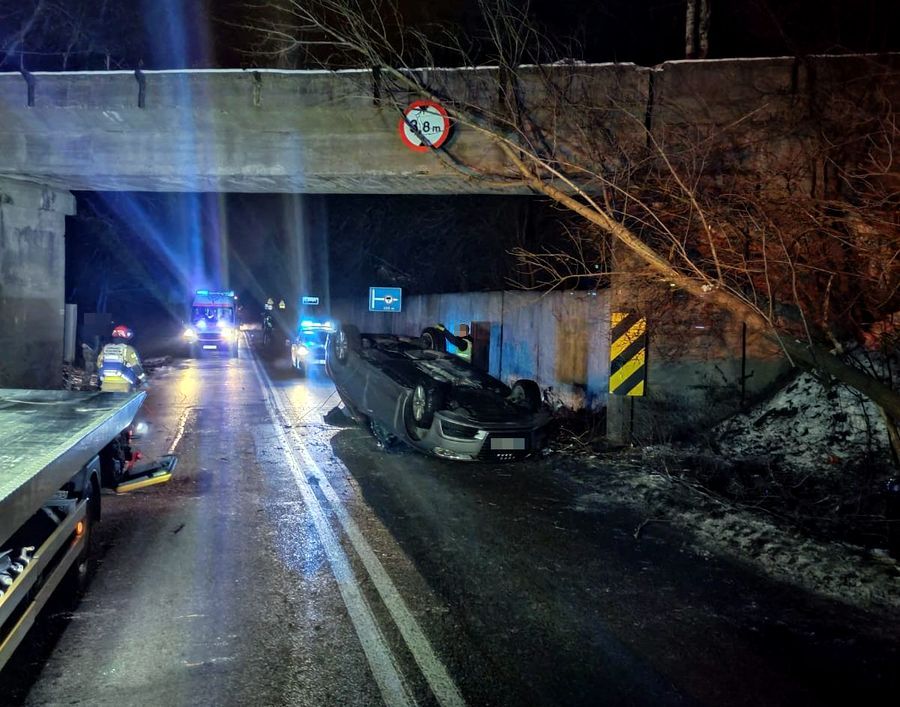 Na zdjęciu pojazd leżący na dachu oraz służby ratunkowe