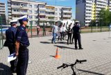 Fotografia kolorowa. Na zdjęciu widocznych trzech policjantów oraz dzieci patrzące na tor przeszkód.