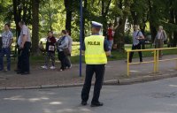 Fotografia kolorowa. Na zdjęciu policjant ruchu drogowego nadzorujący rejon skrzyżowania.