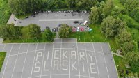 Fotografia kolorowa.Widok z drona Kopca Wyzwolenia i zaparkowanych pojazdów.