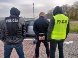 Policjanci pilnujący osoby zatrzymanej na miejscu zdarzenia