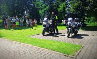 Policjant przy motorach oraz otaczające go dzieci