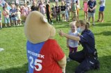 Na zdjęciu policjantka wręczająca medal dziewczynce