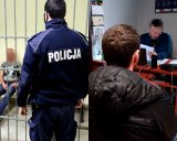 Na zdjęciu zatrzymani mężczyźni nadzorowani przez policjantów