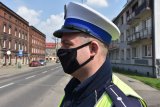 Umundurowany policjant ruchu drogowego w maseczce ochronnej zasłaniającej usta i nos