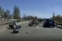 Kadr z filmu przedstawiający upadek na jezdnię kierującego motocyklem oraz pasażera.