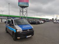 Policjanci znajdujący się w oznakowanym radiowozie podczas kontroli sklepów pod kątem przestrzegania obostrzeń przez kupujących