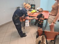 Policjantka wręczająca nagrodę uczestnikowi