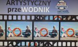 Plakat promujący konkurs &quot;Artystyczny przeWODNIK&quot; zdjęcia dzieci trzymające w rękach koła ratunkowe.