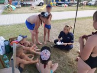 Umundurowana policjantka rozmawiająca z dziećmi podczas spotkania profilaktycznego na terenie basenu.