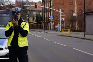 Umundurowany policjant kontrolujący prędkość pojazdów