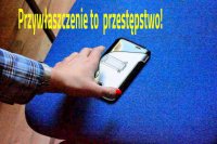 Ręka sięgająca po telefon pozostawiony na krześle. Na górze napis &quot;Przywłaszczenie to przestępstwo&quot;.