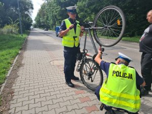 Umundurowani policjanci ruchu drogowego podczas kontroli kierującego rowerem