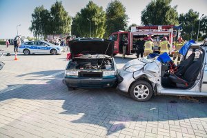 Rozbite pojazdy biorące udział w pokazie. W tle pojazdy Policji oraz Straży Pożarnej