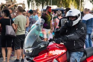 Mężczyzna jadący na motocyklu i wskazujący kciuk do góry