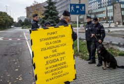 Stojący policjanci przed wjazdem na teren Komendy Wojewódzkiej Policji w Katowicach