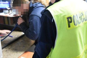 Umundurowany policjant ruchu drogowego przeprowadzający badanie kierującego na zawartość alkoholu w wydychanym powietrzu