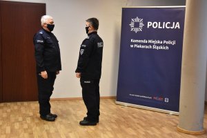 Dowódca uroczystości składa meldunek Komendantowi Miejskiemu Policji w Piekarach Śląskich. W tle baner z nazwą jednostki.