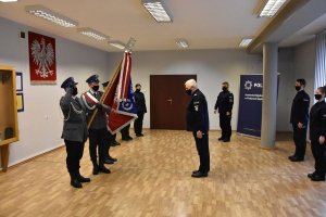 Podinspektor Robert Klimek Komendant Miejski Policji w Piekarach Śląskich wita się ze sztandarem. W tle umundurowani policjanci