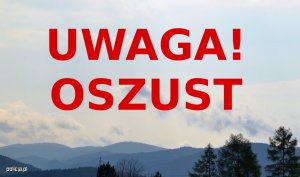 Czerwony napis &quot;Uwaga! oszust&quot;. W tle góry.