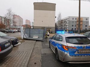 Policyjny radiowóz podczas zabezpieczenia miejsca gdzie przez silny wiatr porwany został blaszany garaż