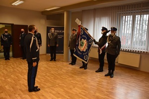 Na sali Komendant Wojewódzki Policji w Katowicach nadinspektor Roman Rabsztyn stoi przed pocztem sztandarowym piekarskiej jednostki. W tle policjanci w umundurowaniu galowym