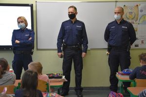 Umundurowani policjanci podczas spotkania z dziećmi w szkole.
