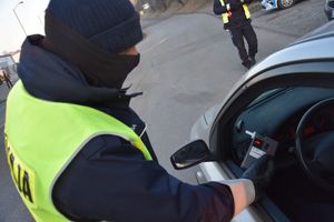 Policjant przeprowadza badanie trzeźwości kierującego samochodem osobowym