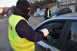 Policjant wręcza kierującemu ulotkę