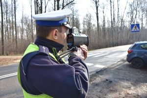 Umundurowany policjant kontroluje prędkość pojazdów