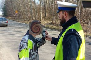 Umundurowany policjant poddający badaniu na zawartość alkoholu kierującego pojazdem