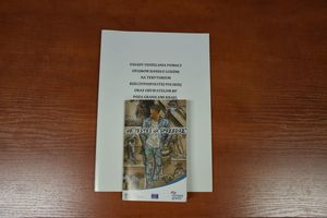 na stole leży teczka z napisem &quot; Zasady udzielanie pomocy ofiarom handlu ludźmi na terytorium Rzeczypospolitej Polskiej oraz obywatelom RP poza granicami kraju&quot;. Niżej broszura informacyjna  z napisem &quot;Nie jestem na sprzedaż&quot;