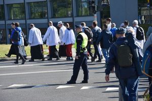 Policjant zabezpiecza przejście pielgrzymów przez jezdnię