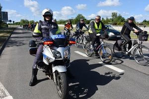 Policjant na motocyklu. W tle rowerzyści