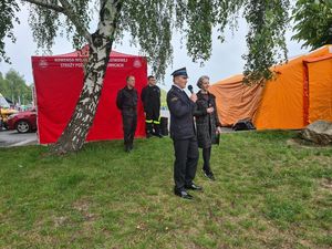 Prezydent Miasta Piekary Śląskie oraz Komendant Państwowej Straży Pożarnej w Piekarach Śląskich podczas pikniku na Kopcu Wyzwolenia. W tle Namioty oraz strażacy.