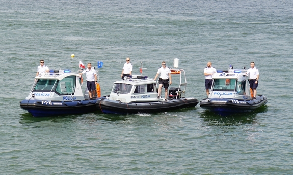 trzy łodzie policyjne na jeziorze a na nich policjanci