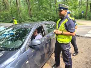 Policjant stoi obok samochodu