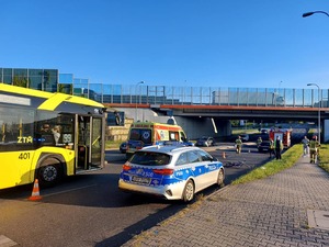 Pojazdy służb ratunkowych zabezpieczają miejsce wypadku drogowego z udziałem rowerzystki. Z lewej strony przejeżdża autobus miejski