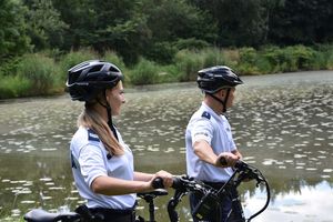 Policjanci na tle zbiornika wodnego