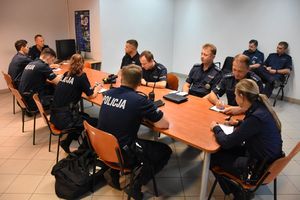 Policjanci podczas odprawy do służby w budynku komendy