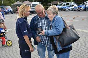 Na zdjęciu policjantka rozmawiająca z uczestnikami pikniku.