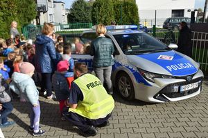 Policjant wraz z dziećmi przy radiowozie