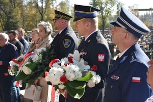 Przedstawiciele służb mundurowych podczas składania wiązanek na grobie