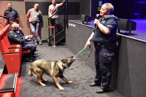 Policjantka z psem służbowym podczas spotkania w kinie