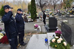 Policjanci oddają honor przed grobem.