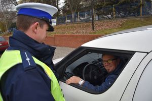 Policjant stoi przy kontrolowanym pojeździe